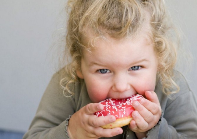 девочка ест пончик