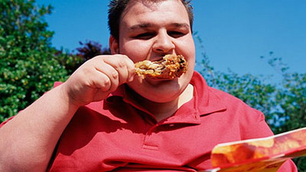 мужчина ест жирную пищу